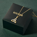 Gold necklace with a Trinity knot design on a Solvar jewellery box against a green background
