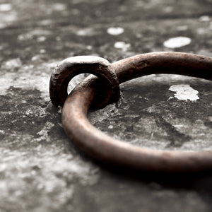 Close-up of a rusty metal ring on a textured surface